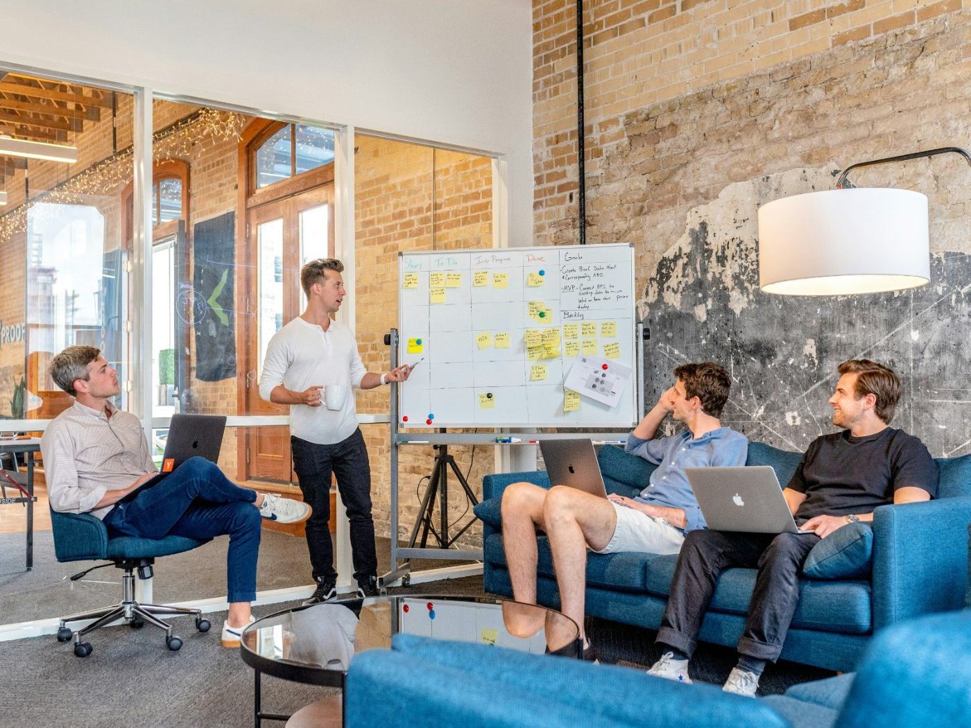 A team round a whiteboard working through stages on a board.