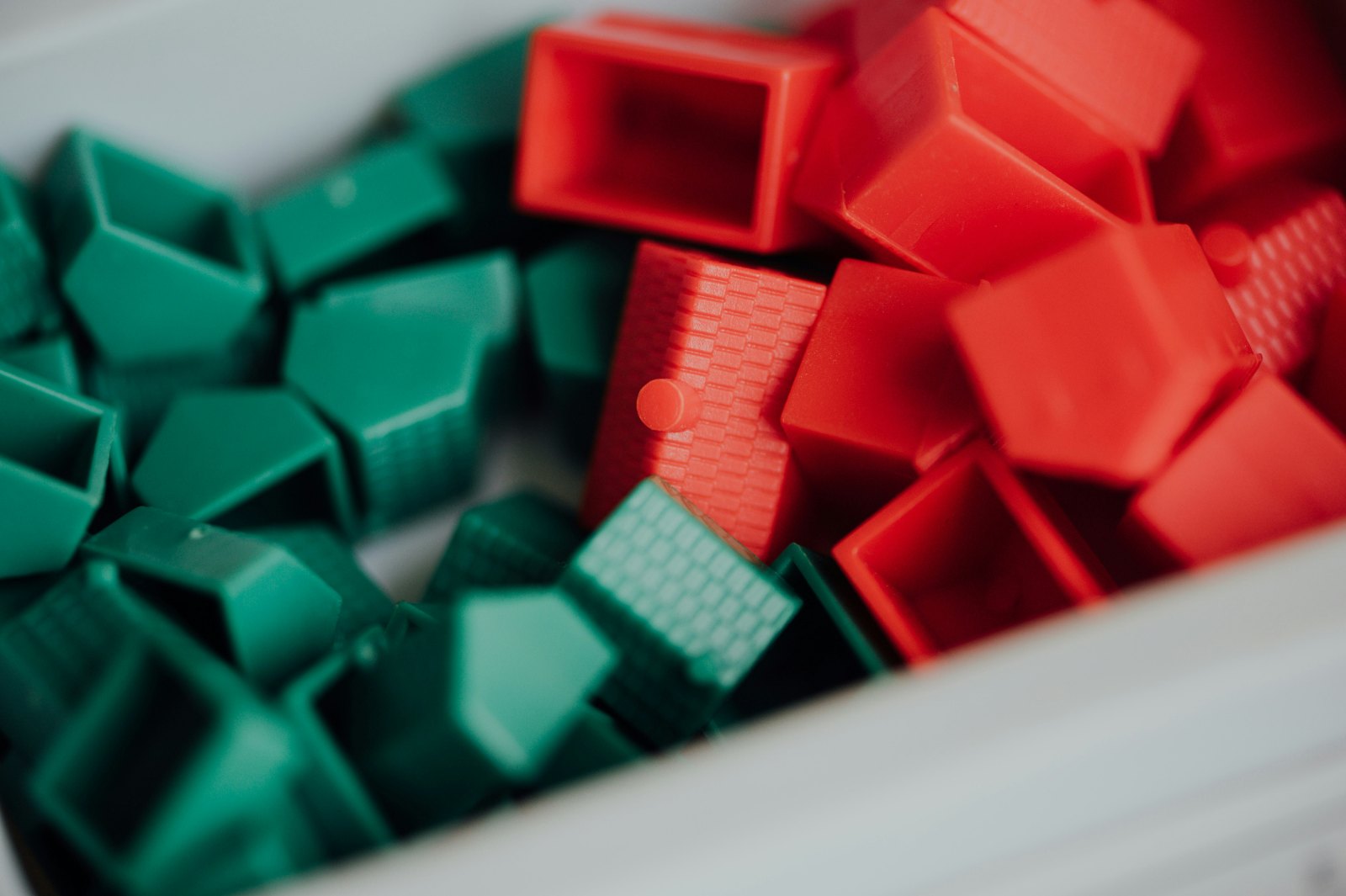 A tray of red blocks beside a tray of green blocks.