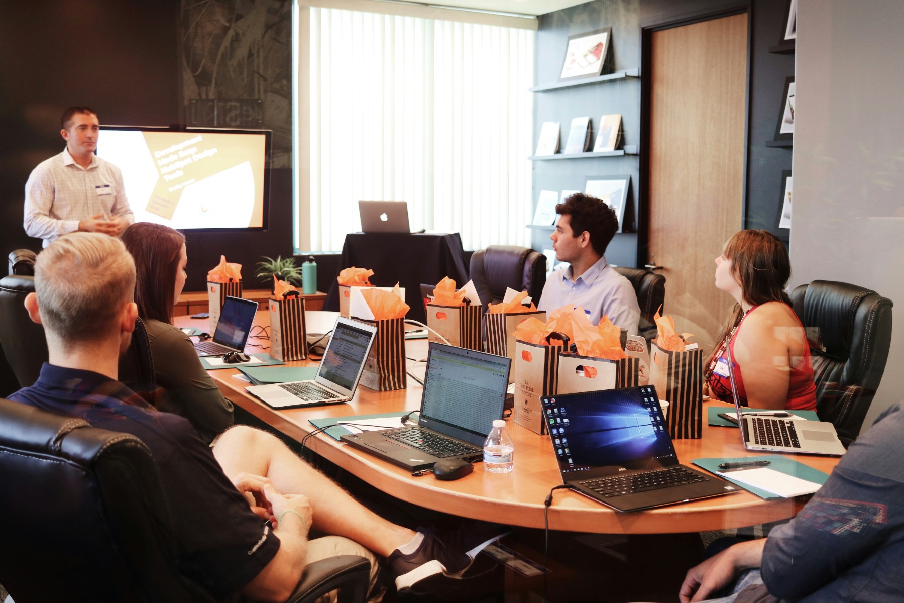 A team around a boardroom table watching a presentation.